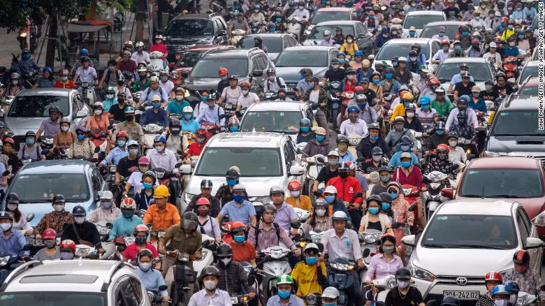How Vietnam managed to keep its coronavirus death toll at zero? ảnh 1 Motorbike riders with face masks are stuck in traffic during the morning peak hour on May 19 in Hanoi.