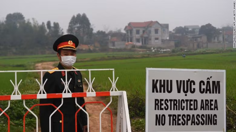 How Vietnam managed to keep its coronavirus death toll at zero? ảnh 3 A Vietnamese People's Army officer stands next to a sign warning about the lockdown on the Son Loi commune in Vinh Phuc province on February 20.