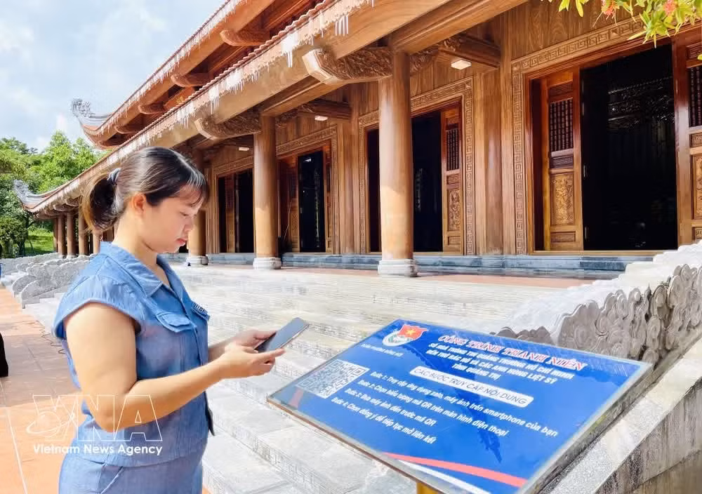 A visitor scans a QR code to access information at the square – memorial temple complex dedicated to President Ho Chi Minh and fallen heroes in Dong Hoi ward, Quang Tri province. (Photo: VNA)