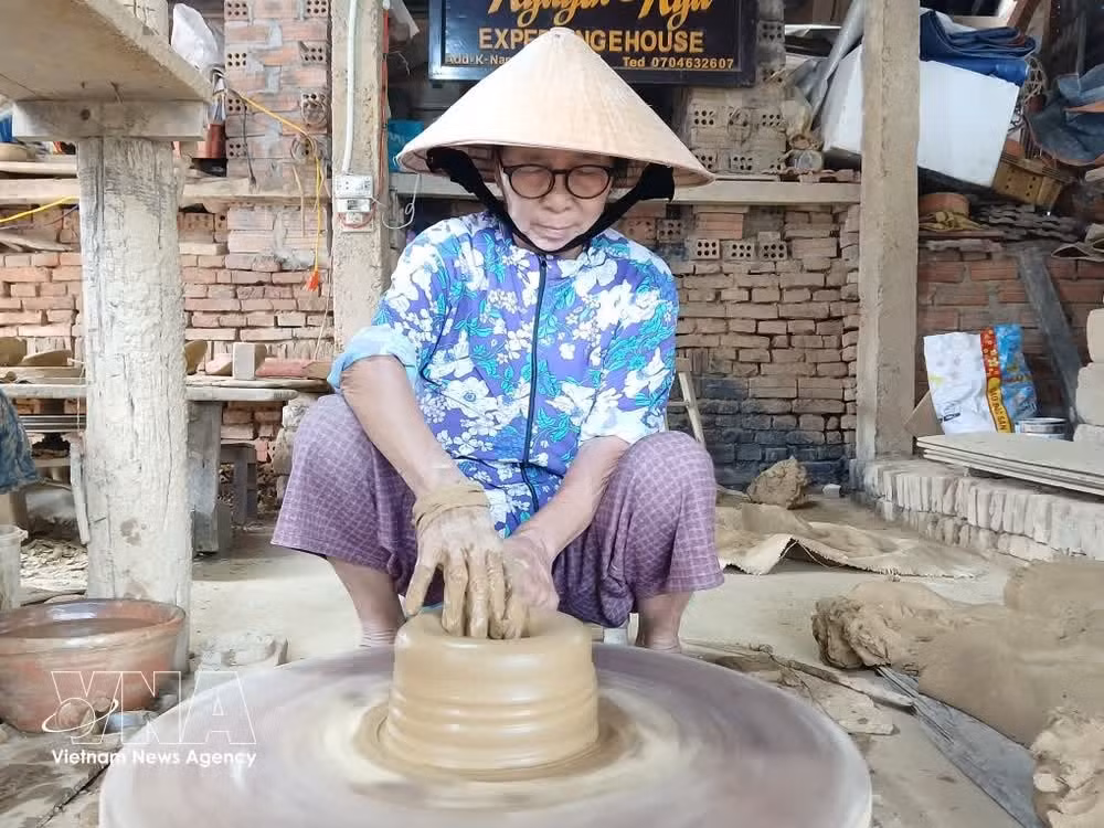 An artisan shapes pottery by hand at Thanh Ha pottery village in Hoi An Tay ward, Da Nang city. (Photo: VNA)