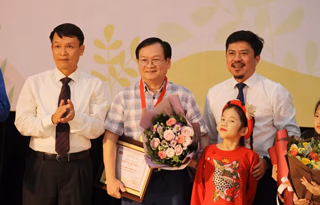 Writter Nguyen Nhat Anh (center) receving the Cricket Knight prize.