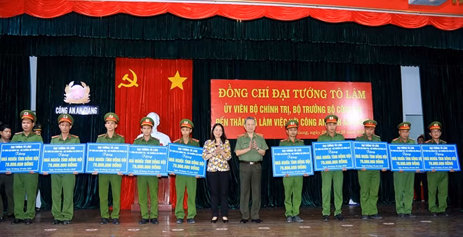 Minister To Lam and An Giang Provincial Party Secretary Vo Thi Anh Xuan presenting financial support to the construction of gratitude houses for communal police officers in the border area.
