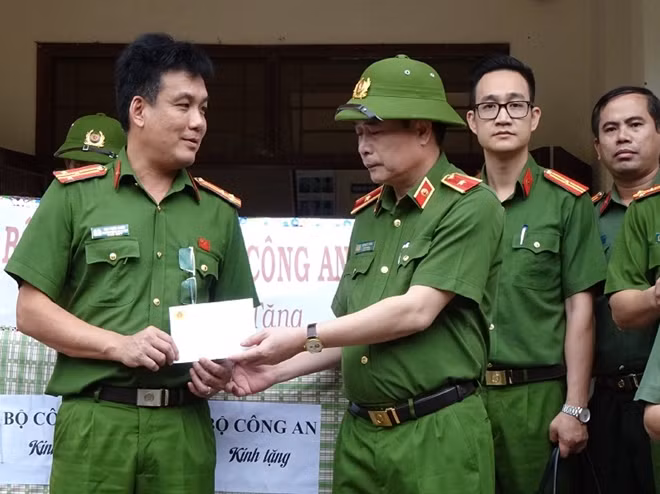 Deputy Minister Le Quoc Hung hands some equipment and materials for storm prevention to the People's Committee and police of Nam Tra My district.