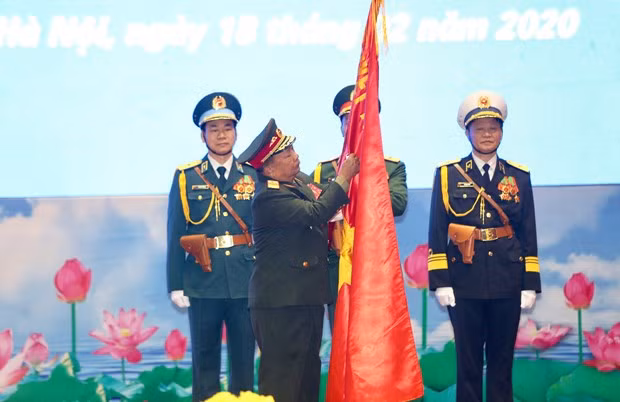 Gen. Chansamone Chanyalath, Politburo member of the Lao People’s Revolutionary Party and Minister of National Defence of Laos, attaches the first-class Issara (Freedom) Order onto the flag of the Vietnam People’s Army at the ceremony in Hanoi on February 18 (Photo: VNA)