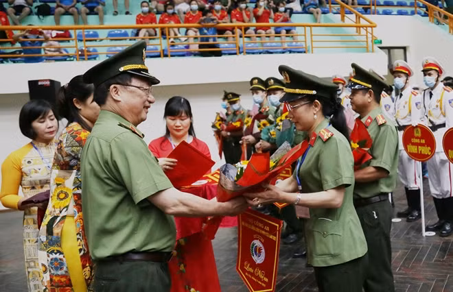 Deputy Minister Nguyen Van Thanh presents flowers and souvenir flags to the delegations participating in the tournament.