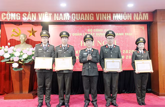 Deputy Minister Nguyen Van Son presenting Certificates of Merit of the MPS to outstanding subunits and officers of the unit.