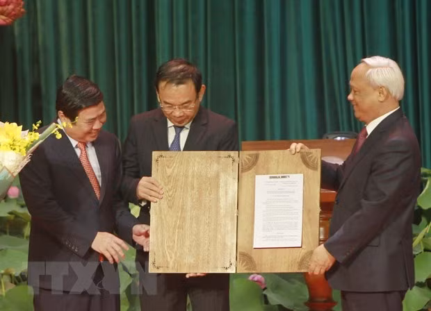Vice NA Chairman Uong Chu Luu (R) hands over NA Standing Committee’s resolution on organising administrative units at the district and commune levels and establishing Thu Duc city to HCM City (Source: VNA) Vice NA Chairman Uong Chu Luu (R) hands over NA Standing Committee’s resolution on organising administrative units at the district and commune levels and establishing Thu Duc city to HCM City (Source: VNA)