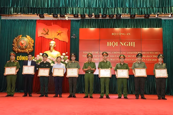 Deputy Minister Le Quy Vuong awards the Certificates of Merit from the MPS to organizations and individuals who had outstanding achievements in implementing the two plans.