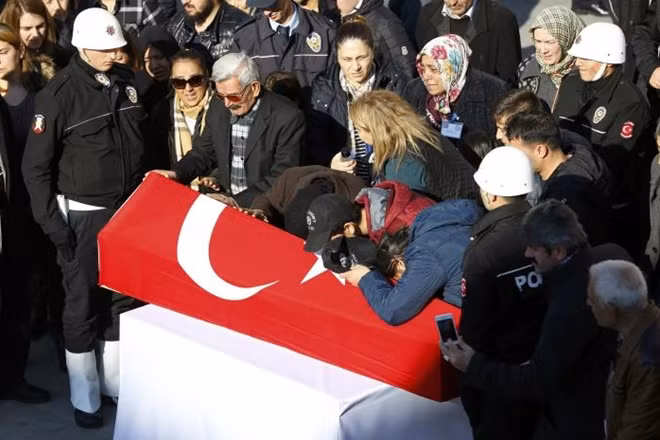 Relatives mourn next to a coffin of a Turkish police officer killed in Saturday's blasts in Istanbul, Turkey, December 11, 2016. REUTERS/Murad Sezer