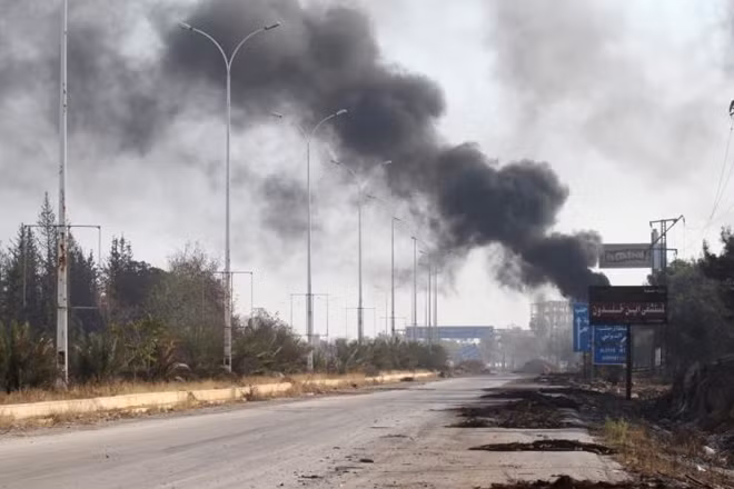 Smoke rises near a damaged road in Dahiyet al-Assad, west Aleppo city, Syria. (Photo: Reuters)