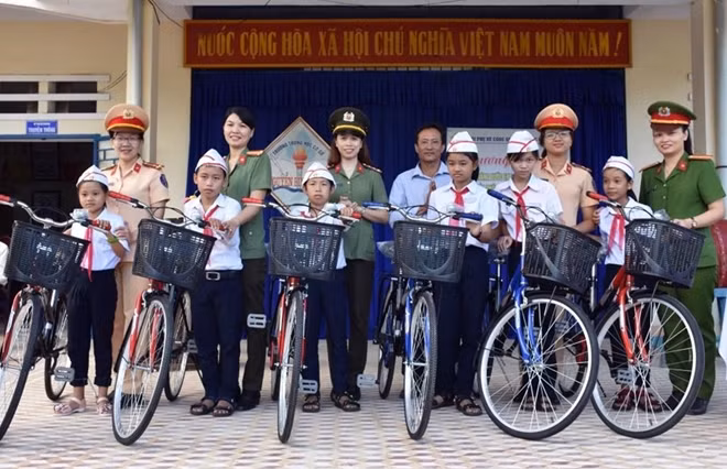 Police women present bikes to poor students in Quang Nam.