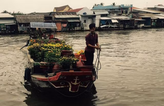 • Boat carrying flowers from Ben Tre docking at the Vinh Thuan Embankment