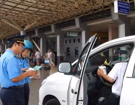 Transport inspectors check a taxi at Tan Son Nhat International Airport. Photo by VnExpress/Kien Cuong