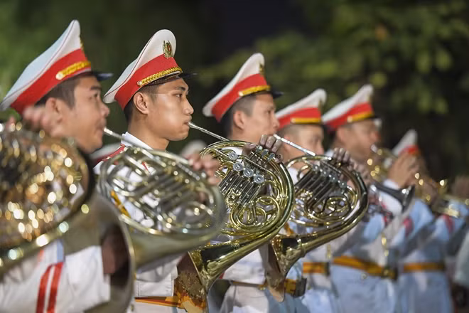 The Public Security Ceremonial Band marches playing music through the pedestrian street around Hoan Kiem Lake.