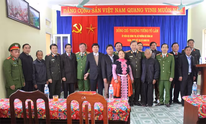 Minister To Lam presenting gifts to village heads, reputable people and families in extremely difficult states in the two communes of Hang Kia and Pa Co in Mai Chau district.
