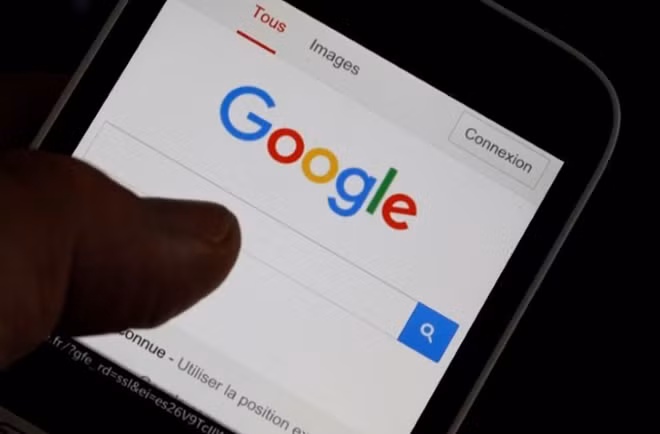A man holds his smartphone which displays the Google home page, in this picture illustration taken in Bordeaux, Southwestern France, August 22, 2016. REUTERS/Regis Duvignau