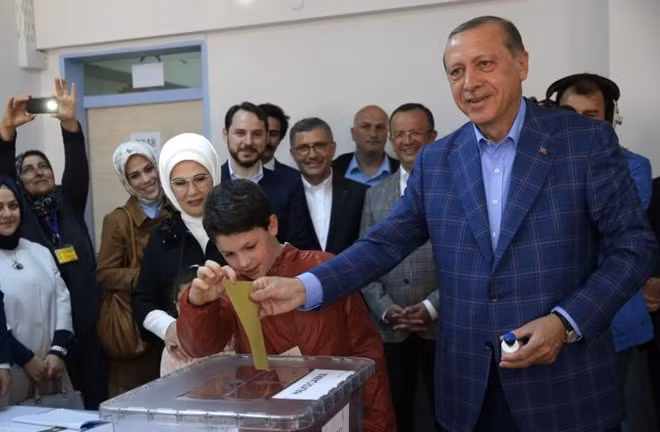 Turkish President Tayyip Erdogan (R) with his wife Emine casts his ballot at a polling station during a referendum in Istanbul, Turkey, April 16, 2017. REUTERS/Murad Sezer