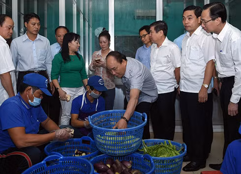 Prime Minister Nguyen Xuan Phuc examines product’s quality.