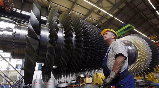 An employee prepares to lift the rotor coil of a Siemens AG Gas Turbine class H is seen at the German industrial giant Siemens historic construction plant in Berlin. Photo: RT