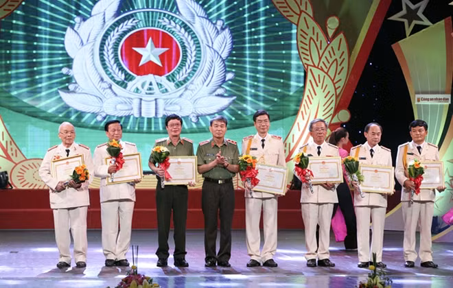 Lieutenant General Tran Ba Thieu, Director of the General Department of Politics awarding Certificate of Merit by the MPS to 9 individuals for their outstanding achievements.