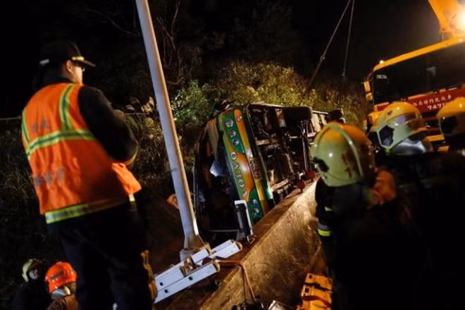 Rescuers gather around a crashed bus in Taipei, Taiwan February 13, 2017. REUTERS/Tyrone Siu