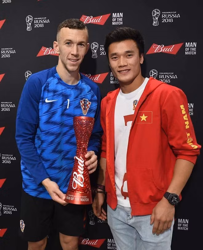 Vietnamese goalkeeper Bui Tien Dung (R) hands the Man of the match award to Croatian player Ivan Perisic.