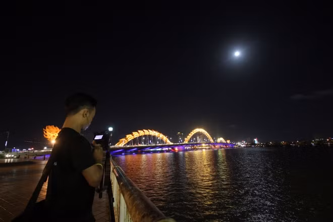 A young man checks his shots of the moon, the most spectacular in 68 years.