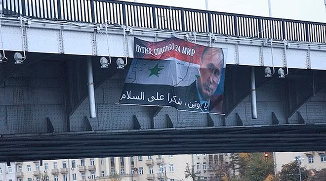 The Russian President's photo on the Syrian flag with a slogan thanking Putin for peace. (Photo: KatasonovaMaria)
