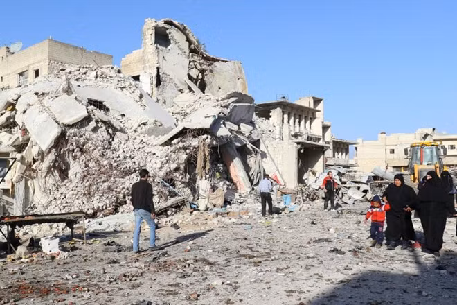People walk at a site hit by airstrikes in the rebel-controlled town of Ariha in Idlib province, Syria February 25, 2017. REUTERS/Ammar Abdullah