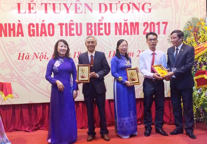 Deputy Minister of Education and Training Nguyen Thi Nghia handing gifts to the outstanding teachers at the ceremony.