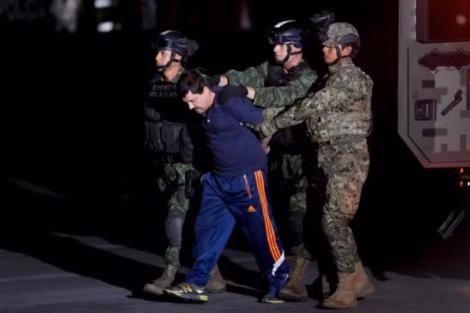 Drug lord Joaquin 'El Chapo' Guzman is escorted by soldiers during a presentation in Mexico City, January 8, 2016. REUTERS/Tomas Bravo