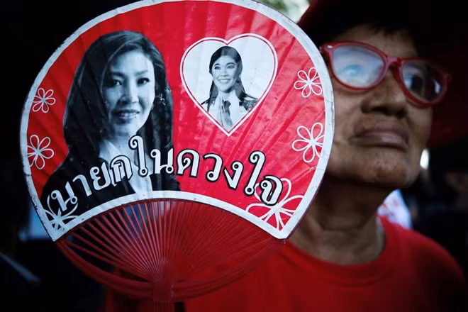 A supporter holds a picture of of ousted former Thai Prime Minister Yingluck Shinawatra while waiting for the verdict in a negligence trial involving Yingluck at the Supreme Court in Bangkok, Thailand, September 27, 2017. REUTERS/Athit Perawongmetha
