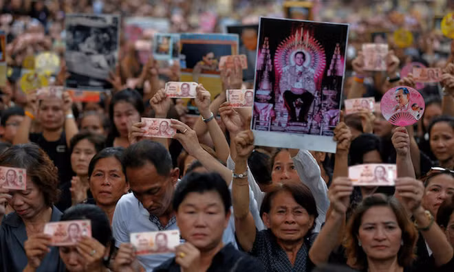 People hold Thai baht notes and portraits of Thailand's late King Bhumibol Adulyadej. (Photo: Reuters) People hold Thai baht notes and portraits of Thailand's late King Bhumibol Adulyadej. (Photo: Reuters)