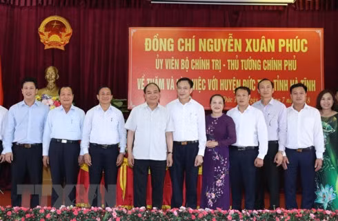 Prime Minister Nguyen Xuan Phuc (fourth, left) and officials of Duc Tho district at the working session