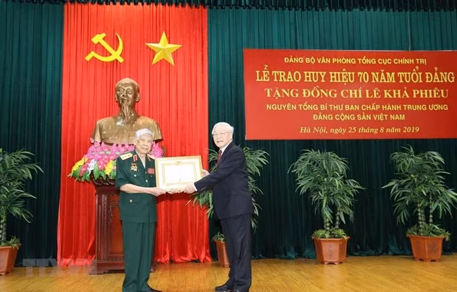 Former Party General Secretary Le Kha Phieu (left) receives a 70-year Party membership badge at a ceremony in Hanoi on August 25. (Photo: VNA)