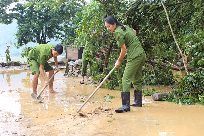 Bo Trach district public security helping people to clean up their homes after flood receded