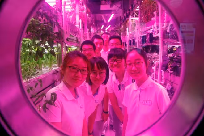 Volunteers smile from inside a simulated space cabin in which they temporarily live as a part of the scientistic Lunar Palace 365 Project, at Beihang University in Beijing, China July 9, 2017. REUTERS/Damir Sagolj