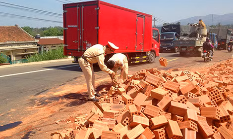 Police quickly clear piles of bricks off road for traffic.