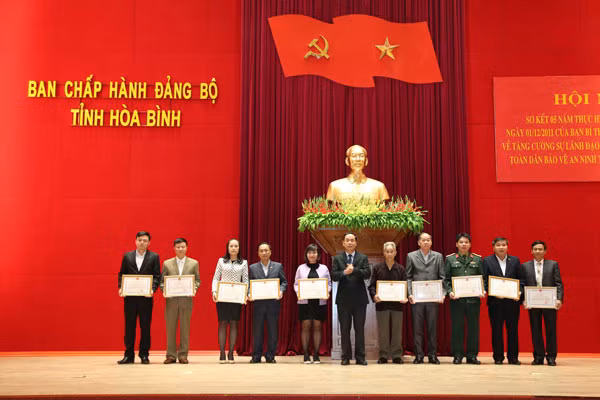 Mr. Nguyen Van Quang, Deputy Secretary of the Hoa Binh Provincial Party Committee, Chairman of Hoa Binh People's Committee handing Certificates of Merit to organizations and individuals.