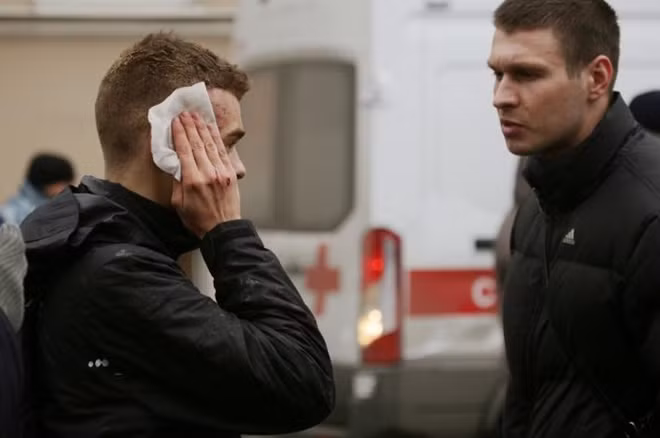 An injured person stands outside Sennaya Ploshchad metro station, following explosions in two train carriages at metro stations in St. Petersburg. REUTERS/Anton Vaganov