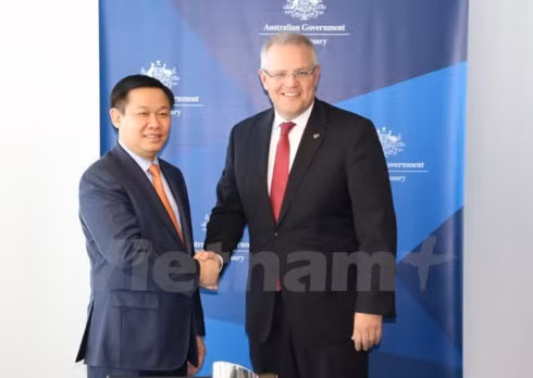 Deputy Prime Minister Vuong Dinh Hue (L) shakes hands with Australian Treasurer Scott Morrison