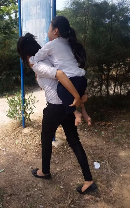 Labour of love: Nguyen Thuy Nga has carried her classmate, Nguyen Thi Mai Gai, on her back to school for eight years. -- Photo baomoi.com