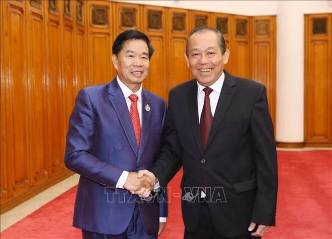 Deputy Prime Minister Truong Hoa Binh shakes hands with Mayor of Vientiane, Laos, Sinlavong Khoutphaythoune. (Photo: VNA)