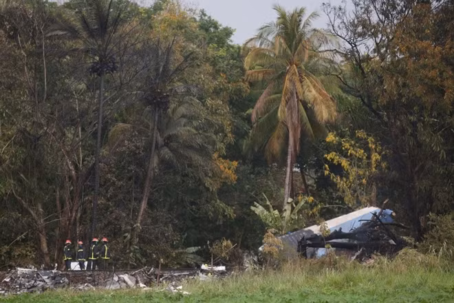 Firefighters work at the wreckage site of a Boeing 737 plane that crashed in the agricultural area of Boyeros, around 20 km (12 miles) south of Havana, shortly after taking off from Havana's main airport in Cuba, May 18, 2018. REUTERS/Alexandre Meneghini