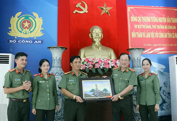 Deputy Minister Nguyen Van Thanh presents gifts to the management board and officers of the Hon Da Bac National Relic Site