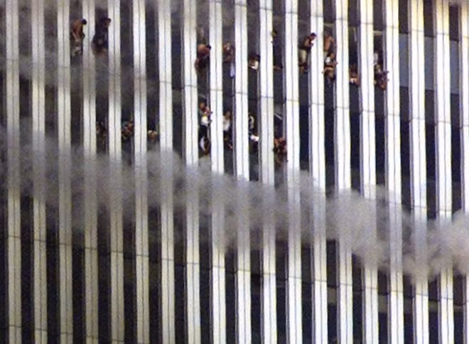 People look out of the burning North tower of the World Trade Center in New York City September 11, 2001. REUTERS/Jeff Christensen.