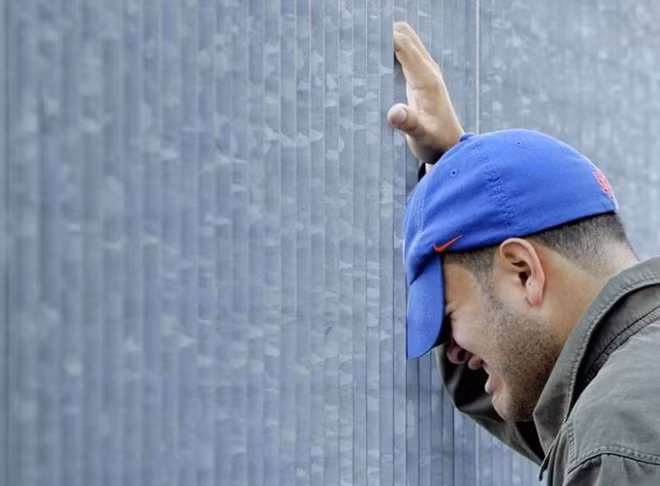 A man grieves outside the World Trade Center site in New York September 11, 2006. REUTERS/Shannon Stapleton