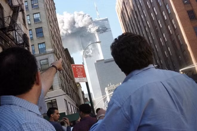 Pedestrians react to the World Trade Center collapse September 11, 2001. REUTERS/Stringer