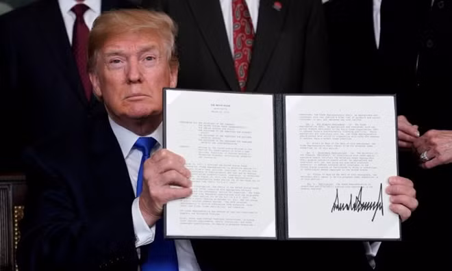 U.S. President Donald Trump holds his signed memorandum on intellectual property tariffs on high-tech goods from China, at the White House in Washington, U.S. March 22, 2018. REUTERS/Jonathan Ernst/File Photo
