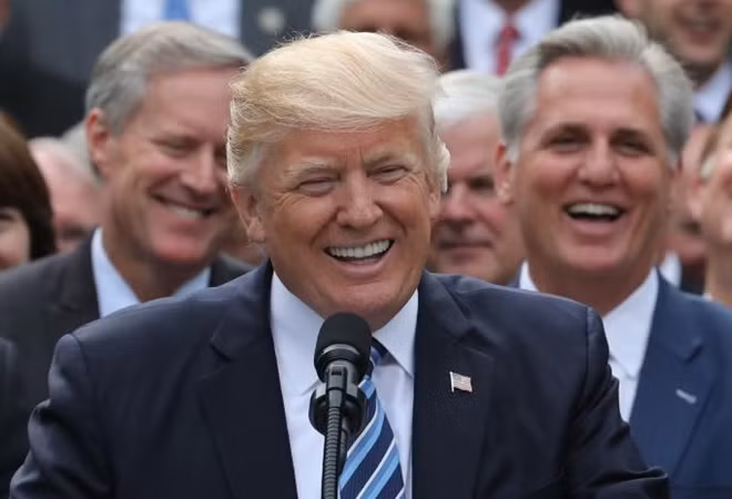U.S. President Donald Trump (C) stands between House Freedom Caucus Chairman Rep. Mark Meadows (L) and House Majority Leader Kevin McCarthy (R) as they listen to House Majority Whip Steve Scalise (front) talk as Congressional Republicans gathered with the president in the Rose Garden of the White House after the House of Representatives approved the American Healthcare Act, to repeal major parts of Obamacare and replace it with the Republican healthcare plan, in Washington, U.S., May 4, 2017. REUTERS/Carlos Barria